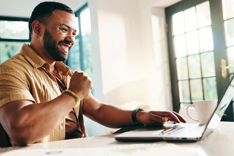 Customer using a laptop at home, representing financial fitness and building healthy money habits with Peake Credit Union