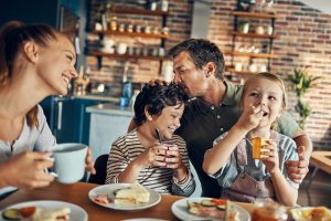 Family sharing a meal together at home, representing financial fitness through alignment with values, lifestyle, and goals.