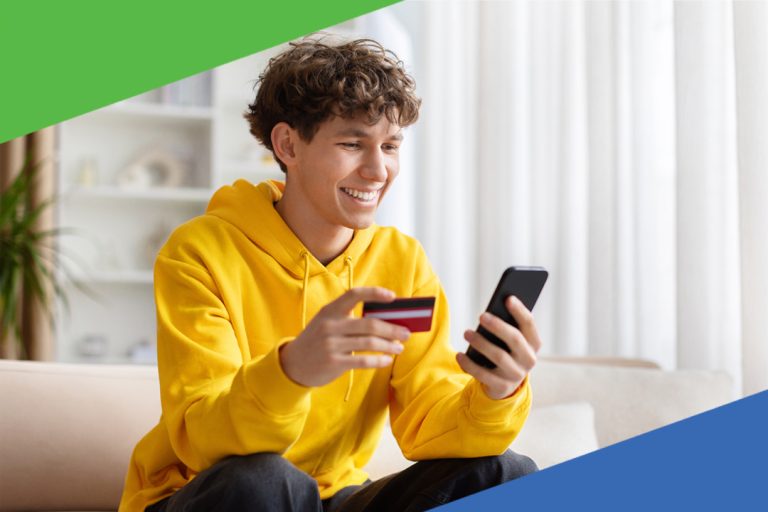 young teen male looking at phone with credit card