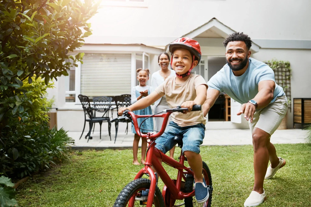 Learning bicycle and proud dad teaching his young son to ride