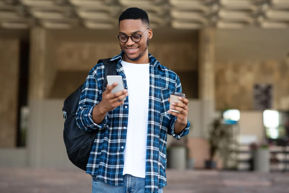 Portrait of african american guy texting sms on smartphone
